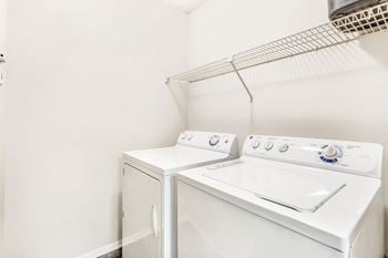 A white washing machine and dryer in a small laundry room.